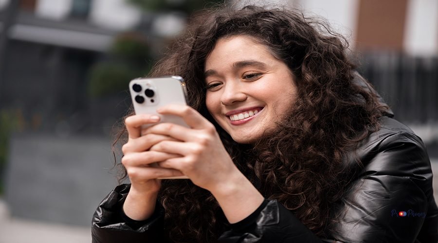 A young smiling woman blogger influencer is using her smartphone