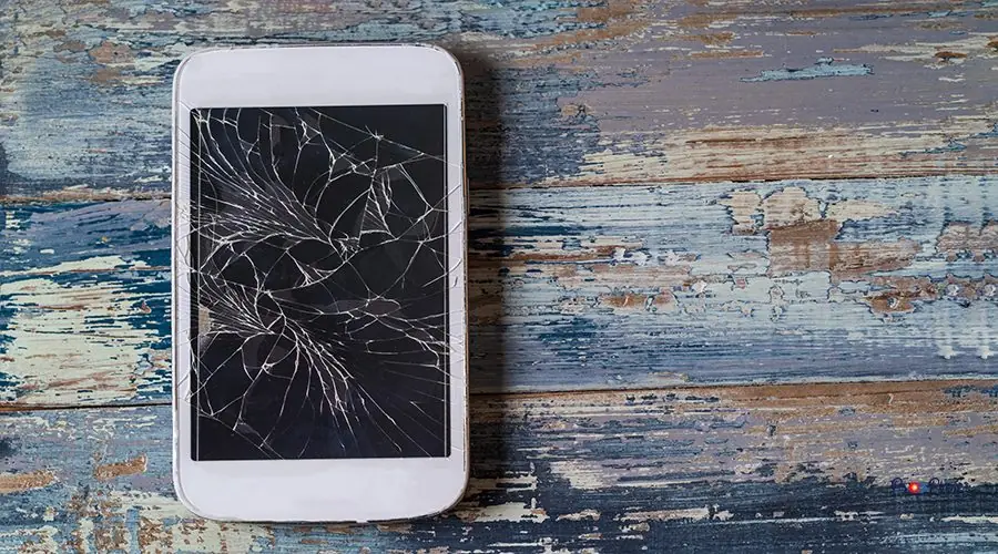 Broken mobile phone with cracked display on blue wooden background, flat lay Broken mobile phone with cracked display on blue wooden background, flat lay.