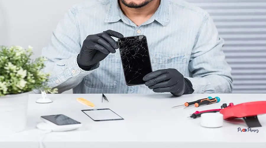 Broken smart phone Technician reparing the broken smart phone with cracked screen.
