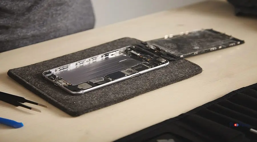 Computer and phone repairment service Close up on dissasembled drowned phone with removed battery and deattached screen in professional repairment lab