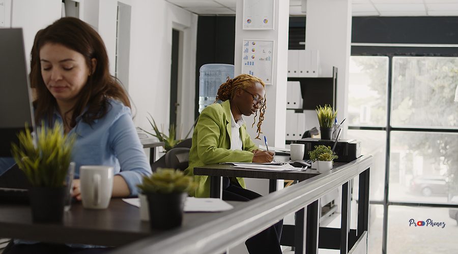 Female assistant writing data on documents, taking notes on papers to create annual report. Executive employee planning investment with analytics and statistics on laptop and files.