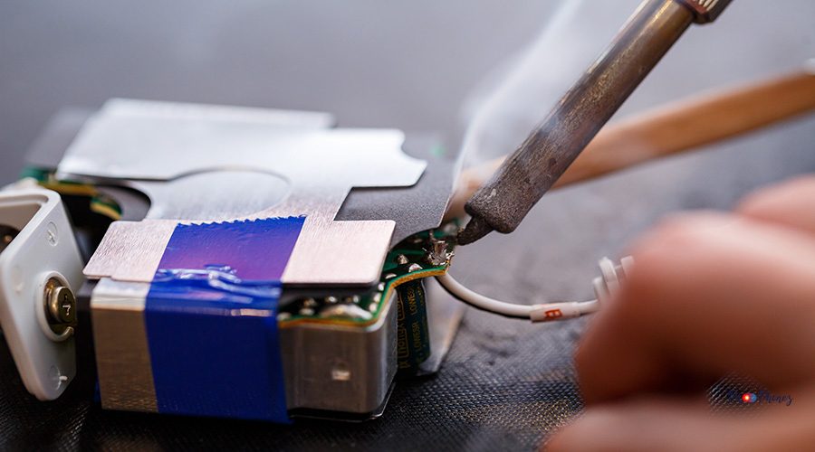 A foreman repairs an electrical appliance in his repair office.