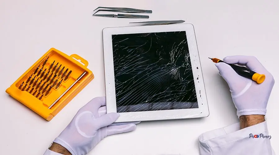 Hands of a gloved technician repairing a tablet with a broken gl Hands of a gloved technician repairing a tablet with a broken glass. Technology maintenance concept
