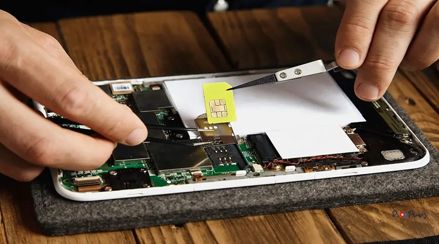 Electronic repair service Hands remove gsm sim card from nest on motherboard in electronic device that was broken