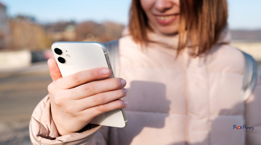 Happy woman recording video blog or making stories on her smartphone. Streaming online podcast in the street