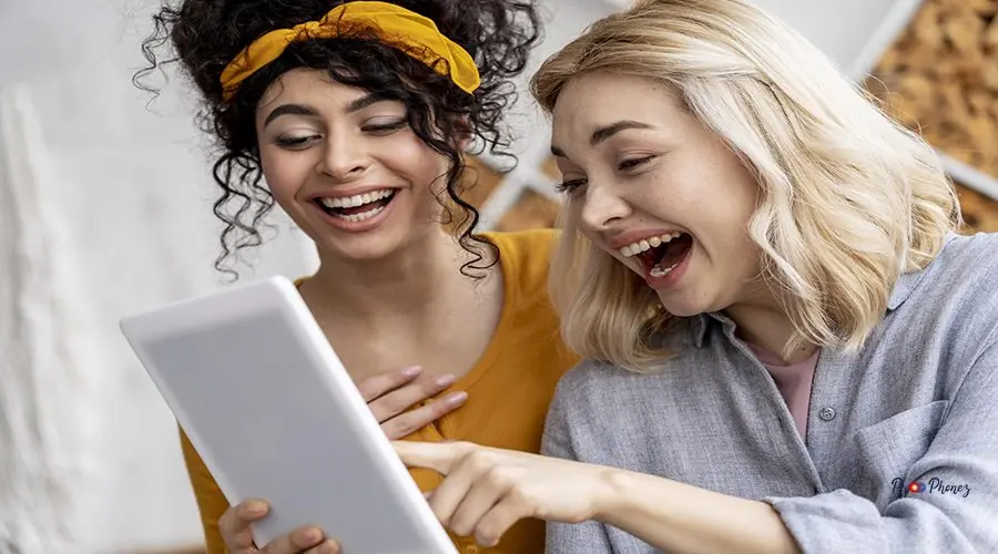 happy-women-laughing-holding-tablet happy-women-laughing-holding-tablet