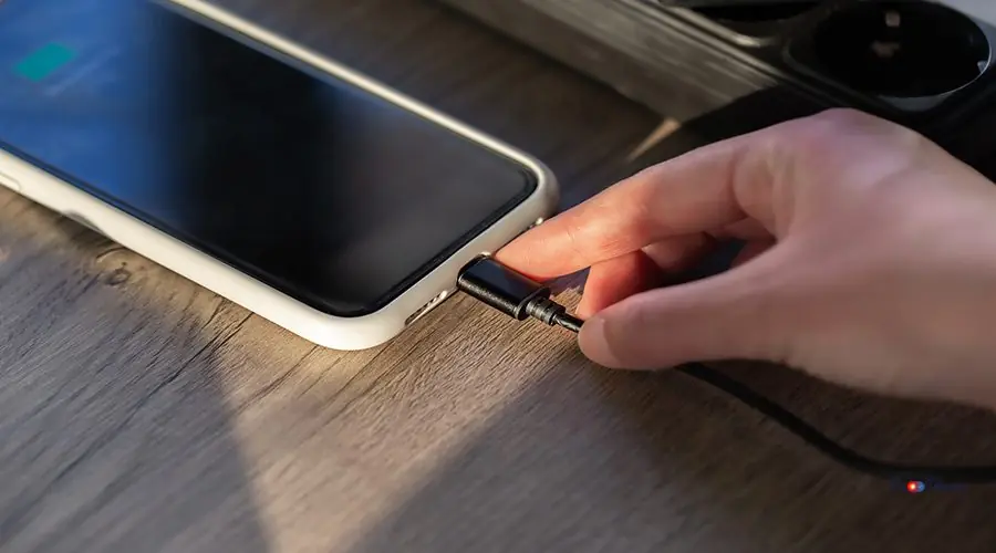 Magnetic cable for charging smartphone, close up. Connecting a magnetic cable to a smartphone for charging, close-up.