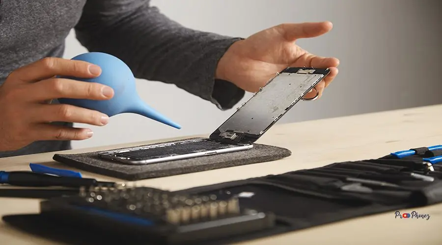 Computer and phone repairment service Man is working carefully in his lab to repair and clean smart phone using syringe to blow out all dust from device