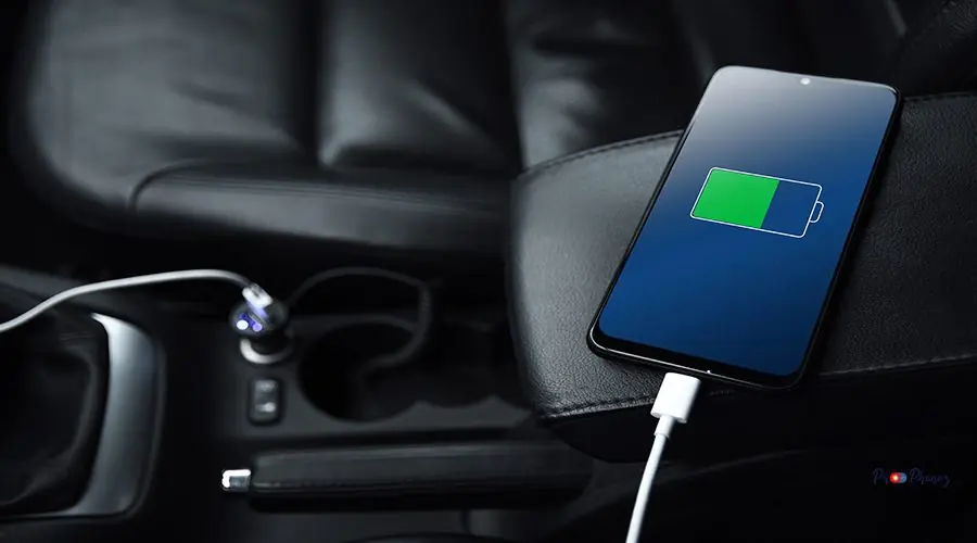 Mobile phone ,smartphone, cellphone is charged ,charge battery with usb charger in the inside of car. modern black car interior Mobile phone ,smartphone, cellphone is charged ,charge battery with usb charger in the inside of car. modern black car interior.