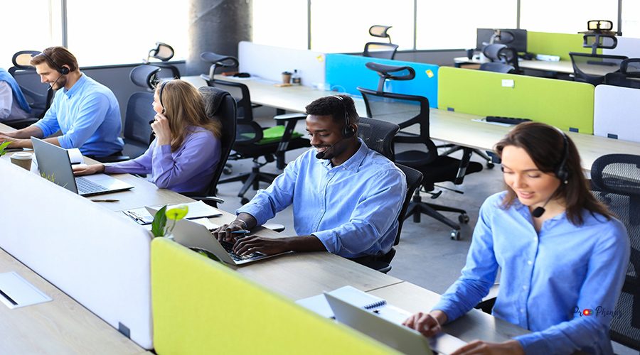 Phone operator working at call centre office helping hiss colleague.
