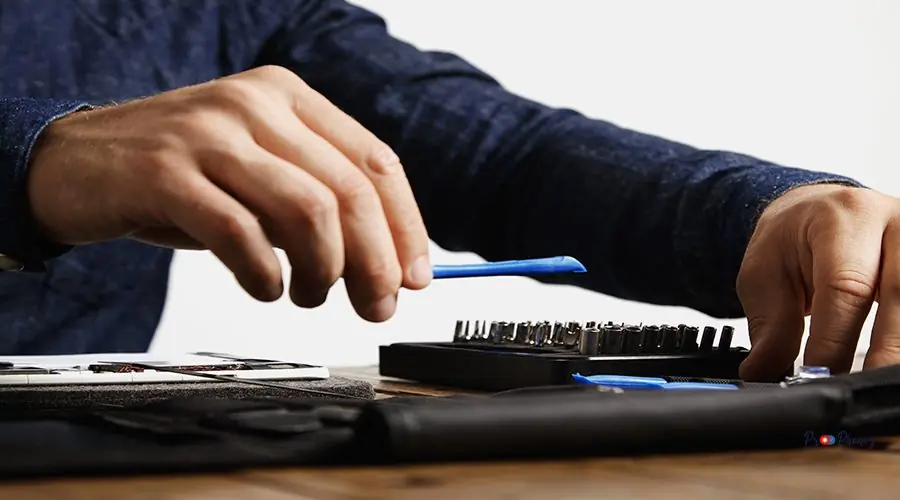 Electronic repair service Professional takes speciall opening plastic instrument from his tool bag to repair tablet