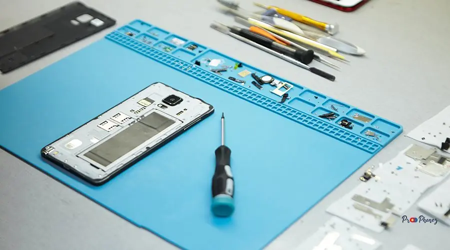 Flat lay of repairman’s workplace with cell phone and special to iphone 13 back glass replacement