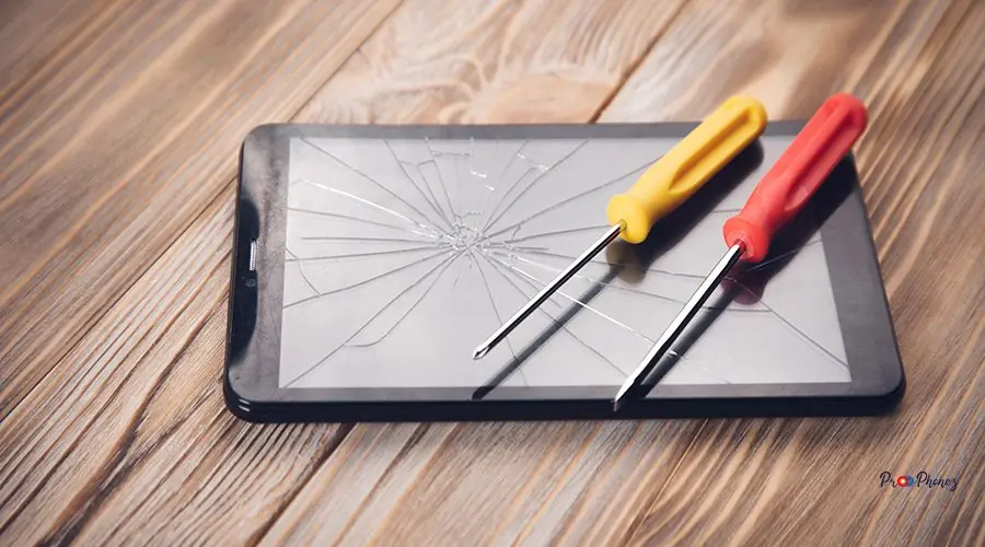 screwdrivers on the broken tablet screwdrivers on the broken tablet on the wooden table