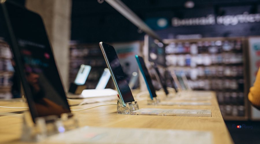 Showcase with smartphones in the modern electronics store. Buy a mobile phone. Many smartphones on the shelf of the technology store
