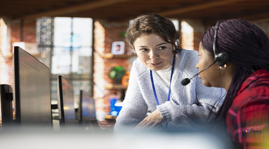 Smiling call center manager providing guidance to intern, addressing questions. Friendly customer support workplace onboarding specialist conducting orientation sessions for new worker