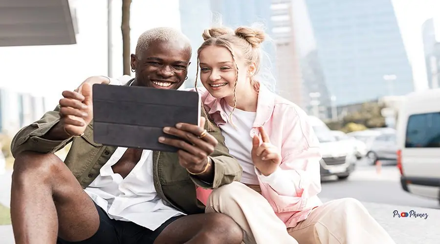 smiling-friends-using-tablet-outdoor smiling-friends-using-tablet-outdoor
