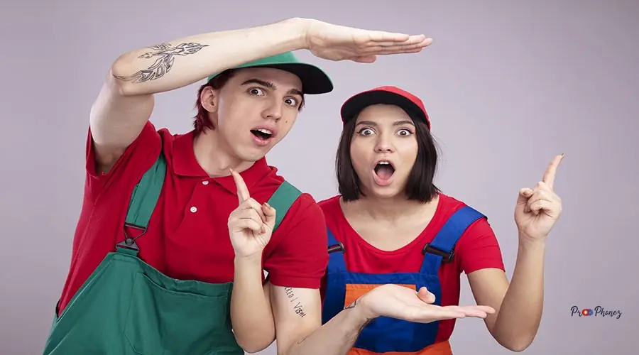 surprised young couple in construction worker uniform and cap looking at camera guy doing size gesture girl pointing up isolated on white background iphone 13 back glass replacement