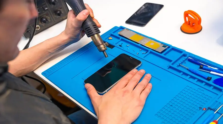 Technician attaching parts of a phone using a soldering iron fix my phone screen