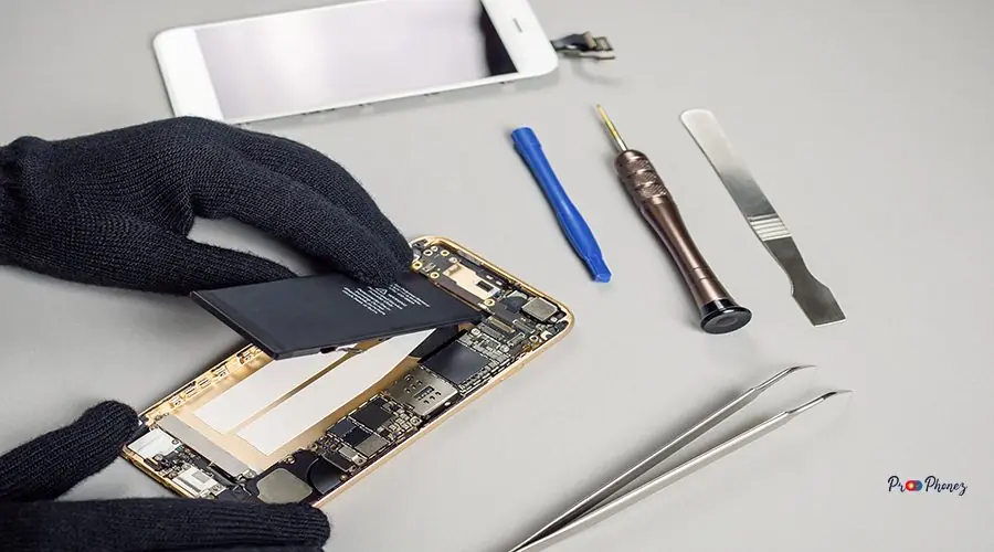 Technician repairing broken smartphone on desk Technician or engineer disassembling components broken smartphone and take off battery for repair or replace new smartphone battery on desk