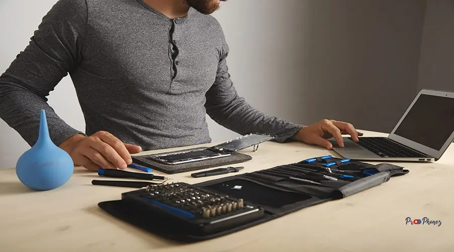 Computer and phone repairment service Unrecognizable man looks guides in internet while repaiting his smartphone , changes screen and battery