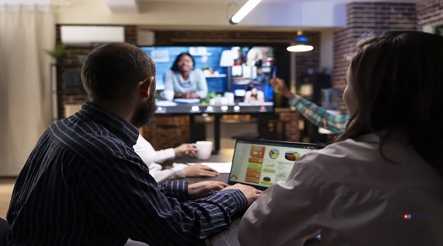 Diverse professionals in virtual meeting Diverse professionals engaged in a video conference, sharing marketing strategies and financial planning. Late night teamwork and group discussions during virtual meeting in modern workspace.
