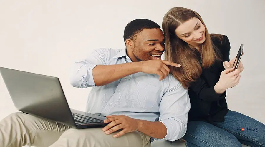 Young international couple working together and use the laptop iPhone Screen